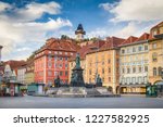 Classic view of the historic city of Graz with main square and famous Grazer clock tower in the background sitting on top of Schlossberg hill, Styria, Austria