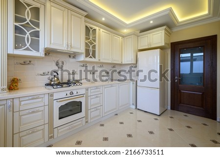 Classic white and beige large luxurious kitchen in studio apartment