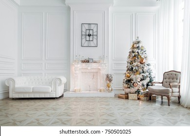 Classic White Christmas Interior With New Year Tree Decorated. Fireplace With Grey Chair, Clocks On The Wall And Presents Under The Tree