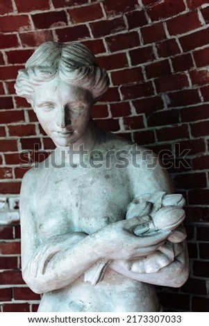 Classic white gyps statue of woman with flowers