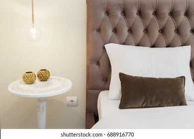 Classic White Nightstand With A Amp Next To A Bed With Velvet Headboard