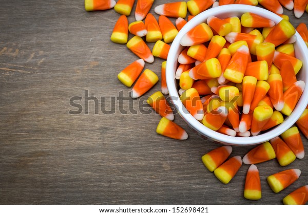 Classic white, orange and yellow candy corn sweets\
for Halloween with copy\
space.
