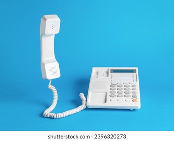 A classic white telephone on a blue background. Classic retro telephone connection. - Shutterstock ID 2396320273