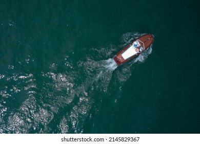 Classic Wooden Boat In Motion Drone View. People On An Italian Wooden Boat, Top View. Old Boat On Lake, Italy.