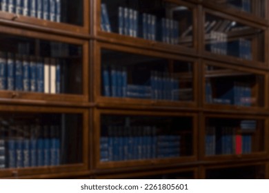 Classic wooden library with books. Education and study. Side view. Blurred.