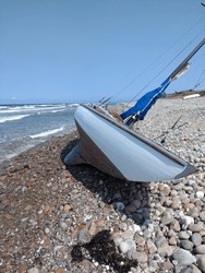 Classic Wooden Sailboat Or Yacht Stranded On A Beach After A Storm.