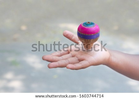 Classic wooden spinning top over the hand