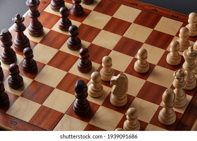 Classic Wooden Tournament Chess Set On Black Background. Chessboard With Pieces. Arrangement Of The Pieces Stems From An Opening Known As Queen's Gambit.