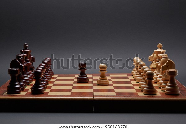 Classic Wooden\
Tournament chess set on black background. Two pawns in centre of\
board other pieces lined\
up