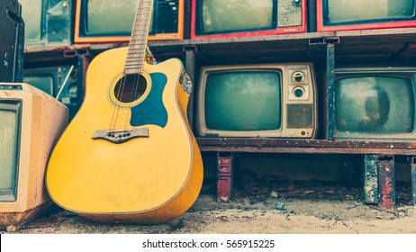 Classic Yellow Guitar Laying Down On Retro Television In Vintage Style.