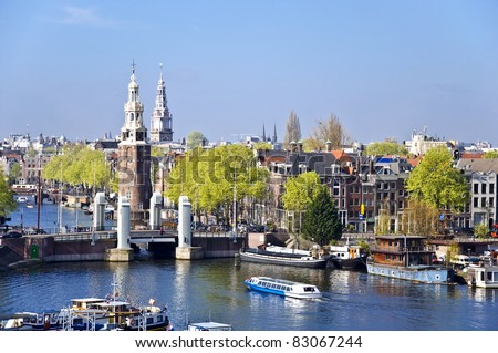 Classical Amsterdam view. Boat floats on the channel on the background of bridge. Urban scene.