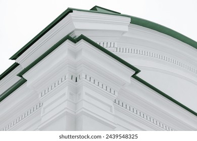 Classical architecture design with white portico elements under green roof. Pillars and corners