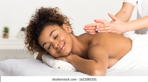 Classical back massage. African-american woman enjoying spa treatment at salon, panorama