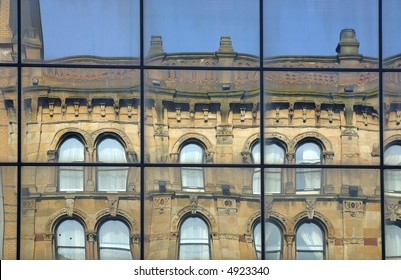 Classical building reflected in the crystal windows of a modern building