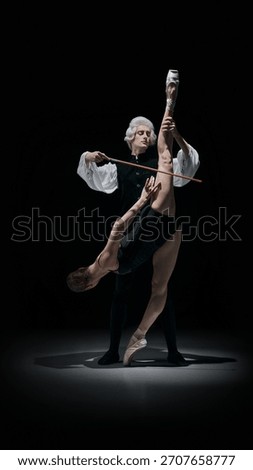 Classical conductor elevating dancer into sculptural instrument-like pose in dramatic theatre scene. Concept of body as musical form, controlled expression, artistic mastery, and cultural performance.