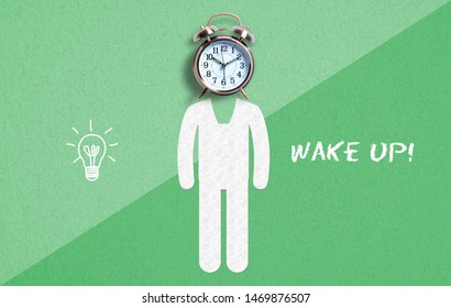 classical copper colored alarm clock as a head of a person in a Wake Up concept on paper background with text