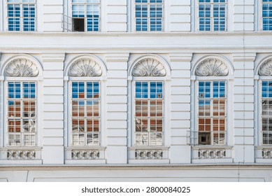 Classical facade with repeated windows and pavement
