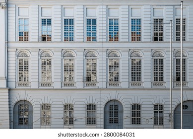 Classical facade with repeated windows and pavement
