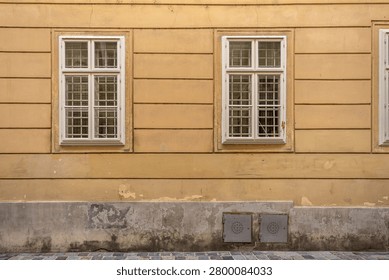 Classical facade with repeated windows and pavement