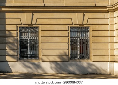 Classical facade with repeated windows and pavement