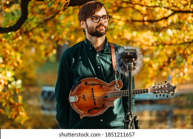 Classical Musician With A Mandolin Recording Outdoors