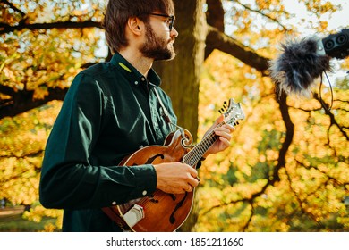 Classical Musician With A Mandolin Recording Outdoors