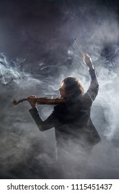 Classical musician violinist with a musical instrument violin, shot in Studio on black background