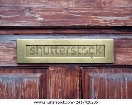 Classical old golden mailbox slot for letters and newspapers in wooden doors with empty space