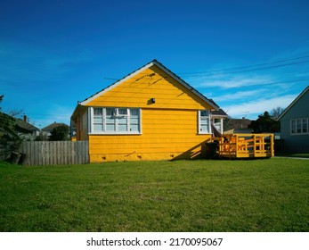 Classical relocatable state yellow cottage house with weatherboard walls. Auckland, New Zealand - June 21, 2022