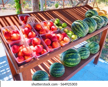 Classical Road Greek Stand Rack Shelf Board Table With Colorful Fruits Peaches Figs Water Melons For Car Traveling Tourists On Greece Rodos Island. Greece Islands Holidays Vacation Car Travel Tours