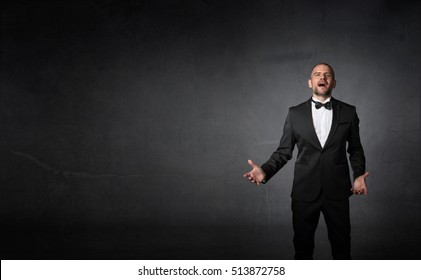 classical singer gestures with hands, dark background