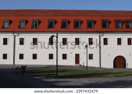 Classical Slovakian old white building and contrasting red roof that surrounds the Bratislava Castle on a cloudless summer day