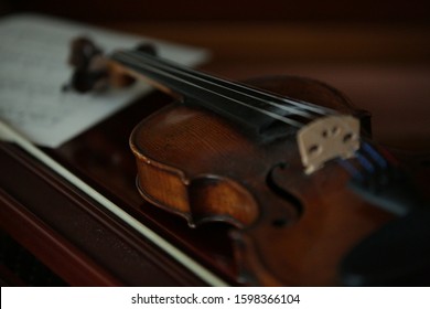 classical wooden violin on a piano - close up