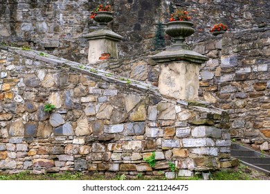 Classical-style Stone Vases With Red Flowers On The Old Stonewall Of The Park Palace