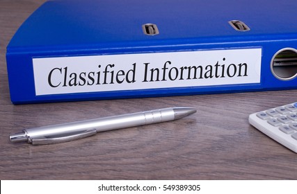 Classified Information - blue binder on desk in the office