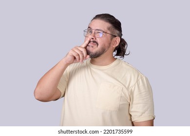 A classless man in his 30s picking his nose for a booger in an unmannerly fashion.