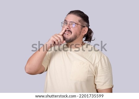 A classless man in his 30s picking his nose for a booger in an unmannerly fashion.