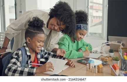 Classroom With Diverse Learners Of Happily African American Students And Teacher Doing Activities Together. The Teacher Is Teaching, Guiding And Talking To The Children In Diverse.