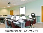 An IT classroom laptops on the desks and an interactive white board with blank screens to add your own image or text