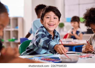 Classroom Portrait Of Smiling Male Elementary School Pupil In Art Class At School