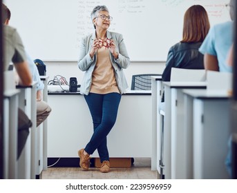 Classroom, presentation and science professor at university of physics or dna model in education, learning and teaching on whiteboard. Students in desk, teacher, leader or presenter woman in college - Powered by Shutterstock