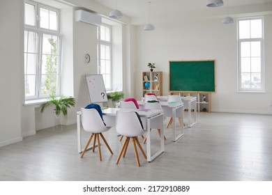 Classroom school.Interior of clean spacious classroom ready for new school year. Empty room with white walls, comfortable desks, chairs, green blackboard, whiteboard. Back to school.
