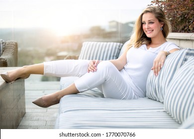 Classy Beautiful Elegant Woman Sitting On Patio Furniture Enjoying Summer Sunset On Rooftop Deck, Smiling Cheerful Portrait