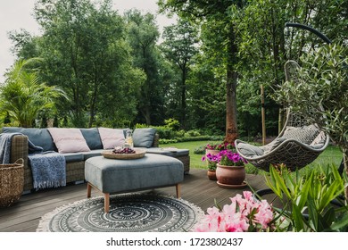 Classy furniture on wooden terrace in green beautiful garden - Powered by Shutterstock