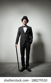 Classy Gentleman With Bowler Hat And Cane Looking Confidently At Camera.