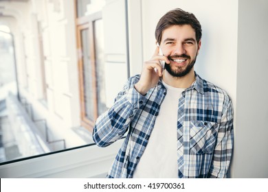 Classy Looking Portrait Of Handsome Young Smiling Italian Business Man Talking On Cell Phone Relaxed On Balcony In A Morning