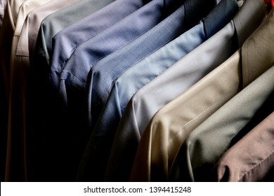 Classy, Stylish, Colorful Men's Formal Long Sleeve Shirts Neatly Arranged And Organized In A Row On A Clothes Rack Hanger For Quality Choice Selection.