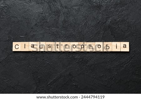 claustrophobia word written on wood block. claustrophobia text on table, concept.
