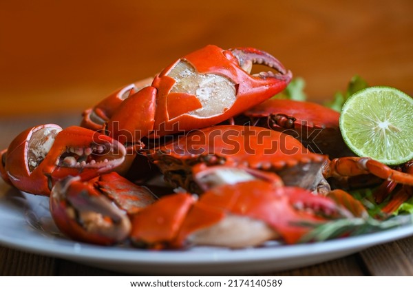 claw crab cooking food seafood plate\
with herbs spices lemon lime salad, fresh crab on white plate\
seafood sauce, boiled or steamed crab red in the\
restaurant