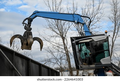 claw grappler machine at work at scrap yard